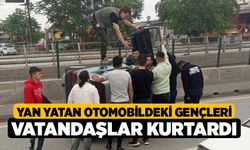 Yan yatan otomobildeki gençleri vatandaşlar kurtardı